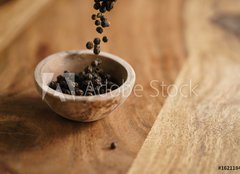 Fototapeta240 x 174  black dry pepper fall into wooden bowl on table, 240 x 174 cm