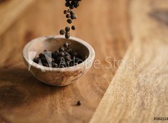 Fototapeta360 x 266  black dry pepper fall into wooden bowl on table, 360 x 266 cm