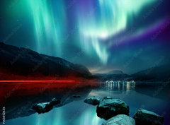 Fototapeta pltno 330 x 244, 163852636 - A large Northern Lights (aurora borealis) display glowing over a mountain pass and reflected on a lake at night. Photo composition.