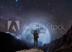 Fototapeta plátno 160 x 116, 205708981 - a man with backpack standing on mountain peak at night, and silhouette mountain with bright full moon and sky full of stars - muž s batohem stojící na vrcholu hory v noci a silueta hory s jasným úplňkem a oblohou plnou hvězd