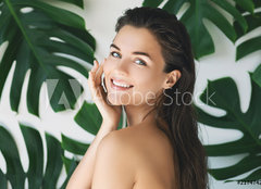 Fototapeta plátno 160 x 116, 217474275 - Portrait of young and beautiful woman with perfect smooth skin in tropical leaves - Portrét mladé a krásné ženy s dokonalou hladkou pokožkou v tropických listech