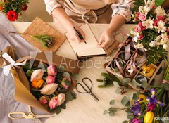 Samolepka fólie 100 x 73, 266667837 - Florist writing in notebook at table - Květinářství psaní v poznámkovém bloku u stolu