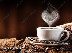 Fototapeta pltno 330 x 244, 286399259 - White Cup Of Hot Coffee With Heart Shaped Steam On Old Weathered Table With Burlap Sack And Beans