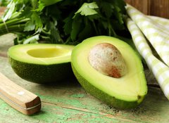 Samolepka flie 100 x 73  ripe avocado cut in half on a wooden table, 100 x 73 cm