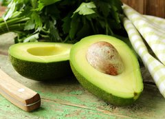 Fototapeta200 x 144  ripe avocado cut in half on a wooden table, 200 x 144 cm