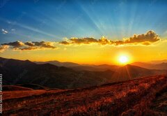 Fototapeta vliesov 145 x 100, 569569643 - Beautiful sun set with sweet clouds between mountains