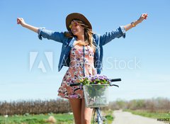 Fototapeta100 x 73  Beautiful young woman with a vintage bike in the field., 100 x 73 cm