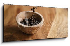 Obraz   black dry pepper fall into wooden bowl on table, 120 x 50 cm