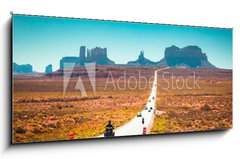 Sklenn obraz 1D - 120 x 50 cm F_AB244433077 - Biker on Monument Valley road at sunset, USA