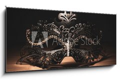 Sklenn obraz 1D panorama - 120 x 50 cm F_AB311256147 - A portrait of a traditional venetian mask on a wooden surface appearing mysteriously out of the darkness.