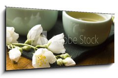 Skleněný obraz 1D panorama - 120 x 50 cm F_AB42047983 - Green tea with jasmine in cup and teapot on wooden table - Zelený čaj s jasmínem v šálku a konvici na dřevěném stole