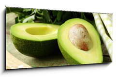 Obraz   ripe avocado cut in half on a wooden table, 120 x 50 cm