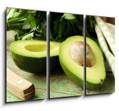Obraz   ripe avocado cut in half on a wooden table, 105 x 70 cm