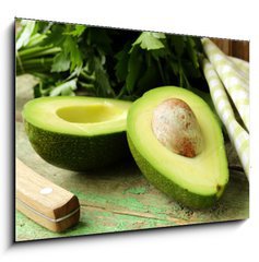 Sklenn obraz 1D - 100 x 70 cm F_E52535934 - ripe avocado cut in half on a wooden table