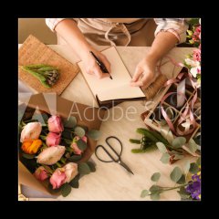 Obraz 1D - 50 x 50 cm F_F266667837 - Florist writing in notebook at table - Kvtinstv psan v poznmkovm bloku u stolu