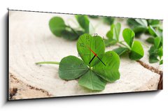 Obraz s hodinami 1D panorama - 120 x 50 cm F_AB110661857 - Green clover leaves on a piece of wood, closeup