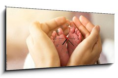 Obraz s hodinami 1D panorama - 120 x 50 cm F_AB305703618 - baby foots in hands on sunshine light