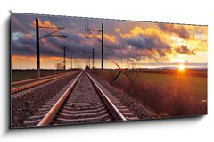 Obraz s hodinami 1D panorama - 120 x 50 cm F_AB81148616 - Orange sunset in low clouds over railroad - Oranžový západ slunce v nízkých mracích nad železnicí