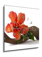 Obraz s hodinami 1D - 50 x 50 cm F_F33085231 - Red hibiscus on a wooden hand statuette - Červený ibišek na dřevěné ruční soše